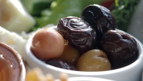 close up of green and black olives in a bowl