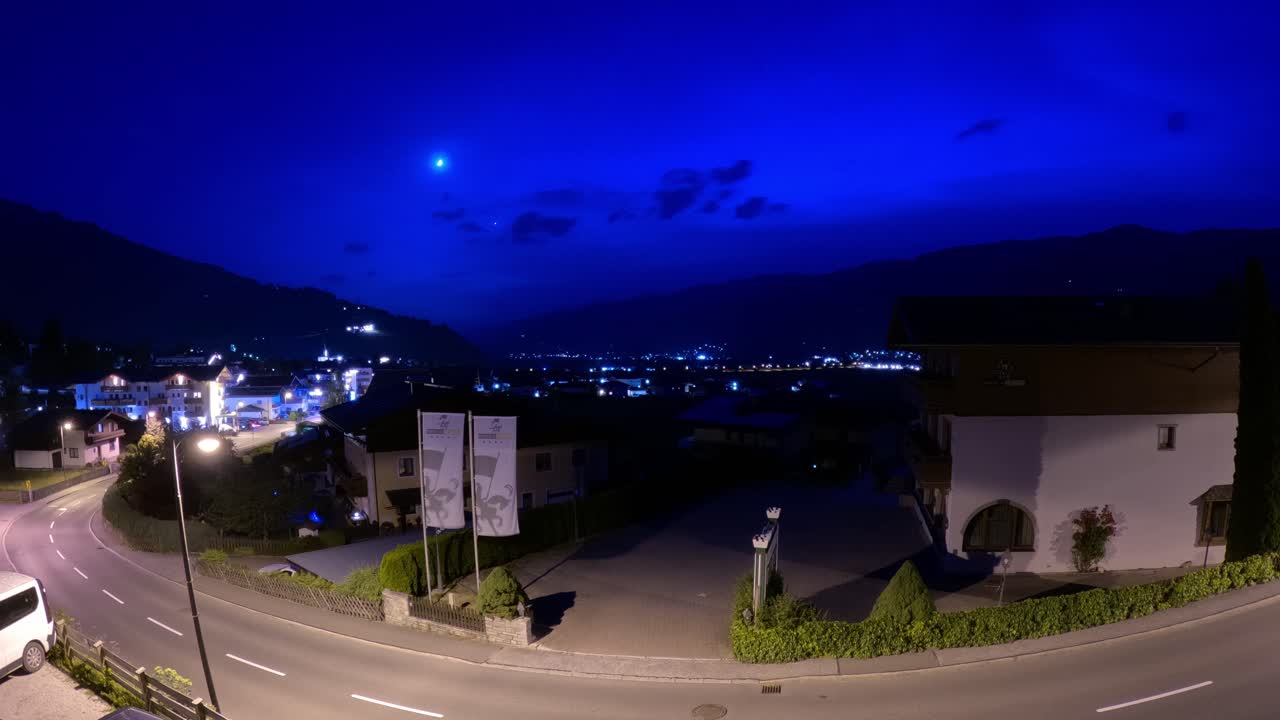 la noche desciende sobre la ciudad de kaprun, austria, mientras pasan los vehículos.