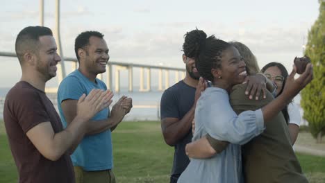 Excited-young-people-congratulating-their-friend-in-park.