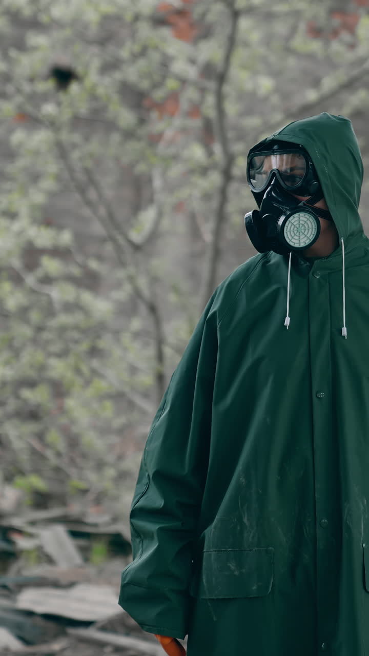 Man in a special suit in destroyed place. Human in chemical protective suit in ruined place. Post-apocalyptic world concept. Real background of abandoned place. Vertical video
