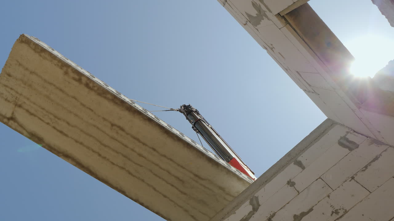 el brazo de la grúa sostiene un enorme panel superior sobre las paredes de la vista inferior de la casa