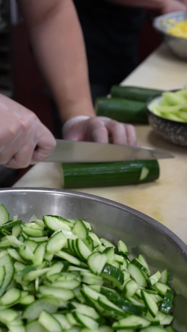 Sous chef cuts cucumber for service in a Japanese restaurant
