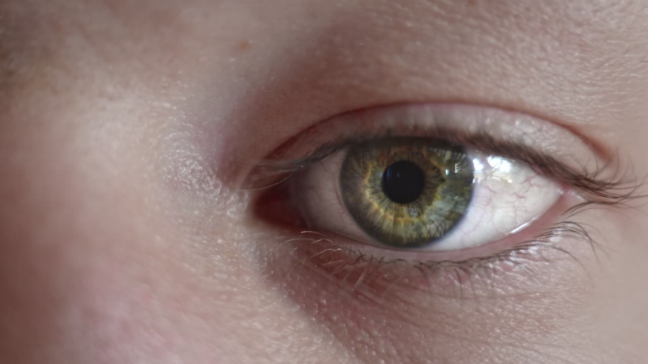 Extreme close-up of green blue eye looking expressionless