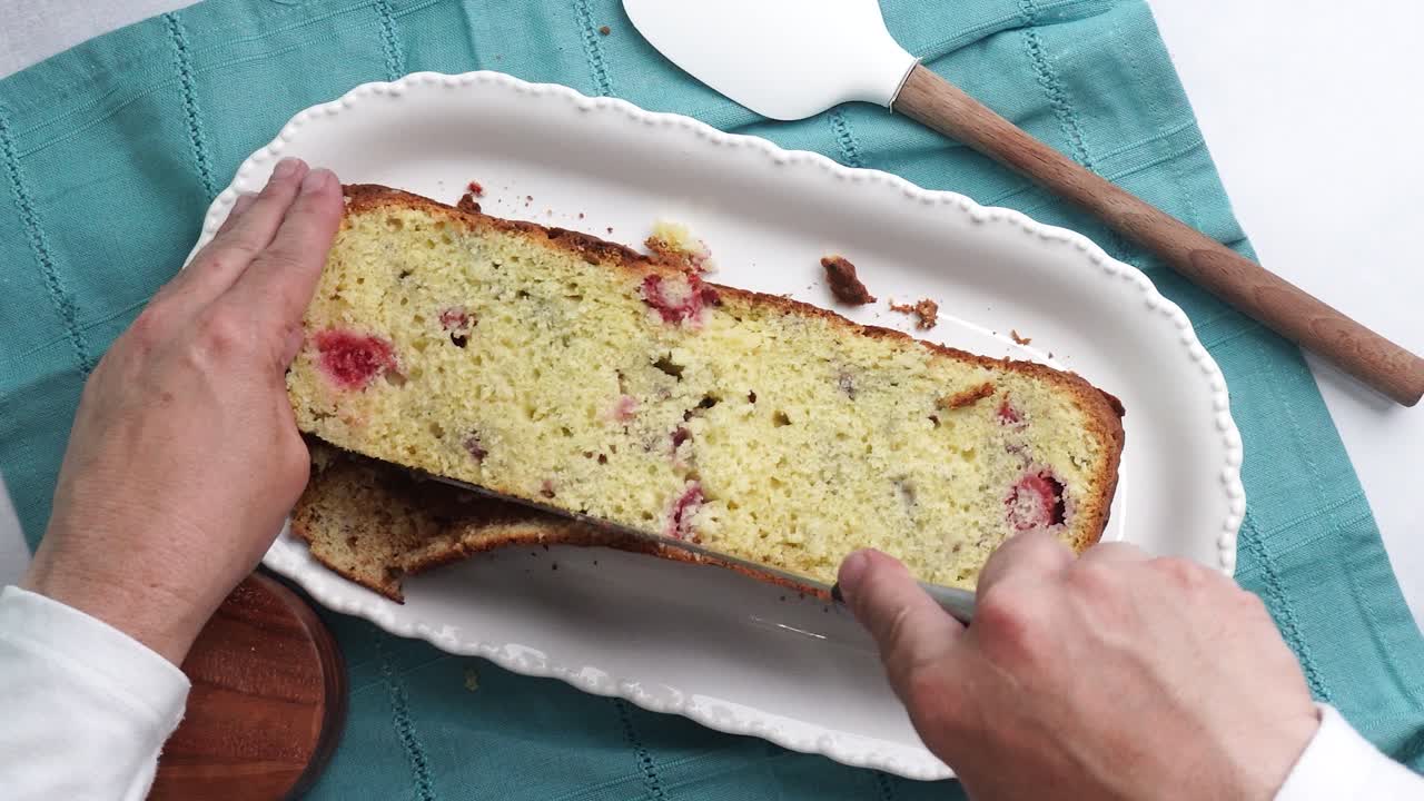 Making a dessert called Red Raspberry Tea Cake made with fresh berries and vanilla buttercream frosting. Great for Tea Parties. Cutting off the top of the cake and placing the top aside on the table