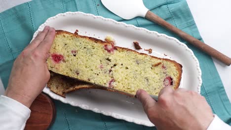 making a dessert called red raspberry tea cake made with fresh berries and vanilla buttercream frosting. great for tea parties. cutting off the top of the cake and placing the top aside on the table