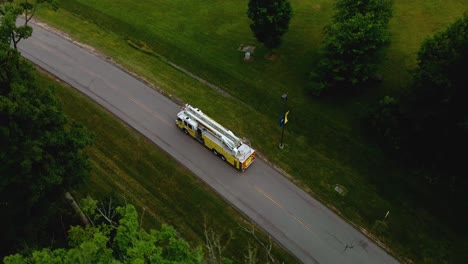 Disparo-De-Un-Dron-Siguiendo-A-Un-Camión-De-Bomberos-A-Lo-Largo-De-Un-Camino-Rural-Oscuro