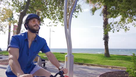 joven montando una bicicleta en la playa.