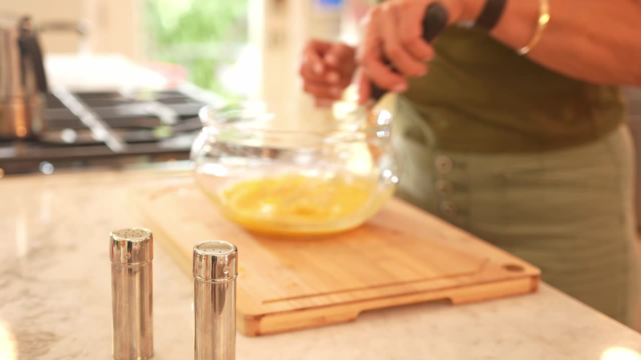 A person whisking eggs in a kitchen