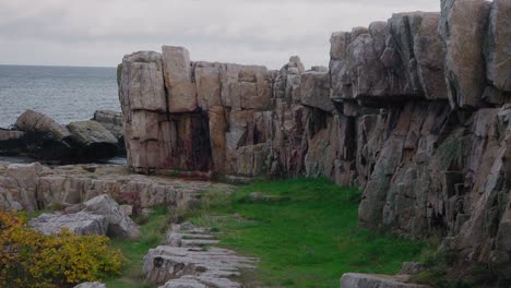 vårhallarna rocks by the sea in simrishamn, south sweden - handheld wide shot