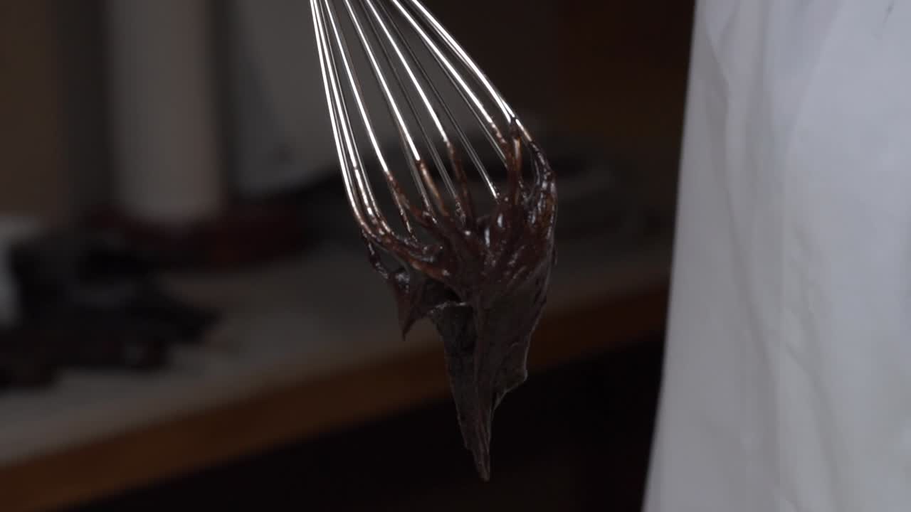 chef wisking bateador de chocalate tiro largo de cámara lenta