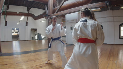 handheld shot of karatekas practicing karate in gym