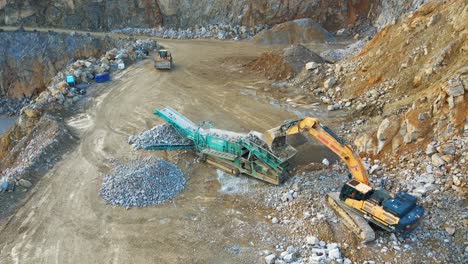 efficient mining operations: an excavator, tracked incline screener, and wheel loader at work at a quarry in germany