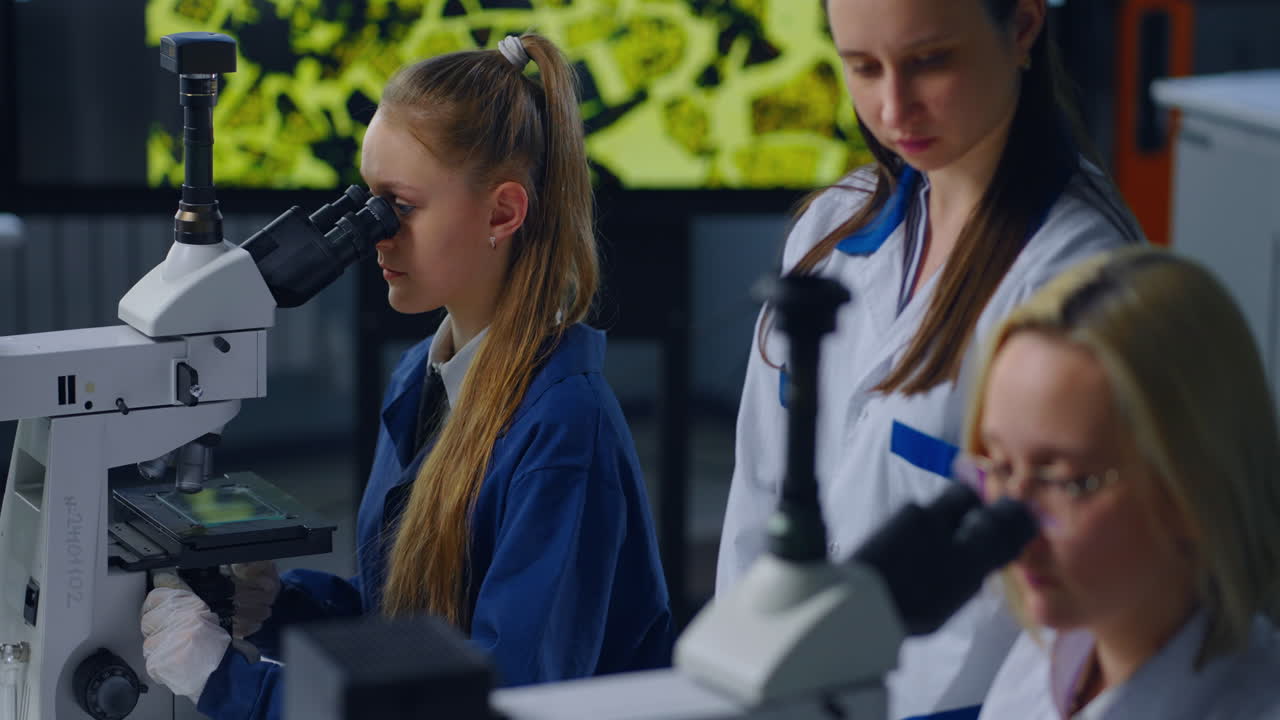 estudiantes usando microscopios en un laboratorio