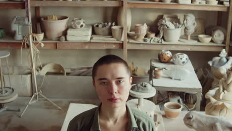 portrait of young woman at work in pottery studio