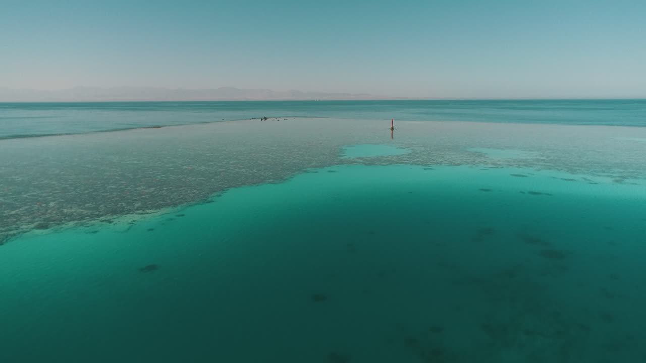 Aerial Shot for the Red Sea of Egypt in the North beside Hurghada with the drone moving forward towards a light house on a coral island of Abu Nuhas Coral island