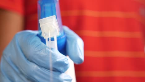 person cleaning with spray bottle and gloves