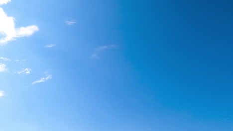 blue sunny sky clears up from white clouds. light spindrift clouds flying quickly by the horizon disappearing from sight.