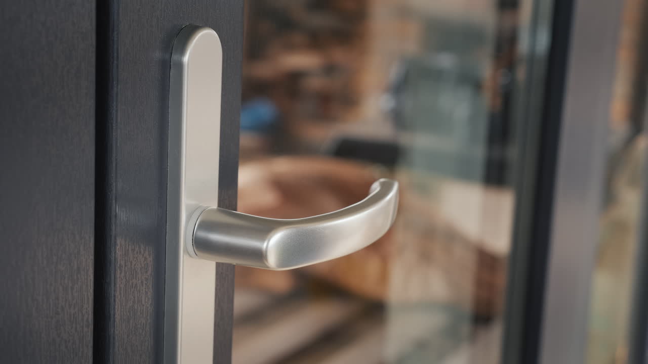 vista lateral de una mano en un guante protector en el mango de la puerta delantera