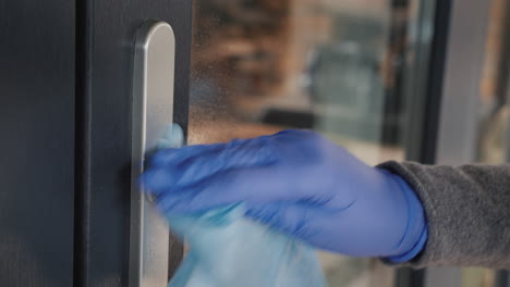 side view of a hand in a protective glove on the handle of the front door