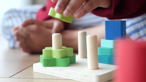 toddler playing with wooden stacking blocks