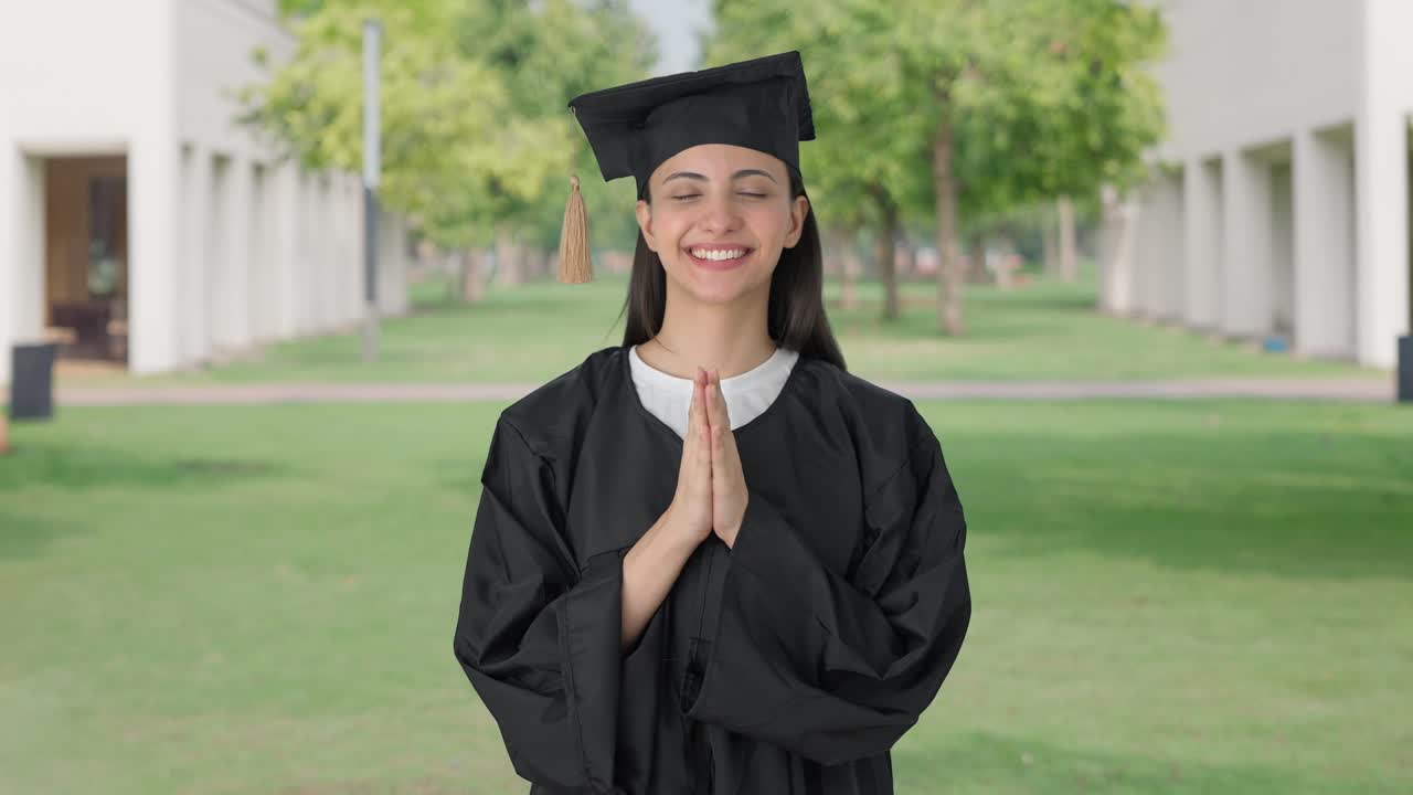feliz chica graduada de la universidad india haciendo namaste