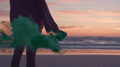Junge-Frau-Hält-Grüne-Rauchgranate-Am-Strand-Bei-Sonnenuntergang