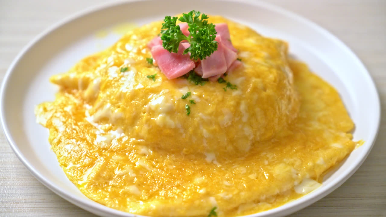 라이스에 햄을 얹은 크리미 오믈렛 또는 햄과 부드러운 오믈렛을 얹은 라이스