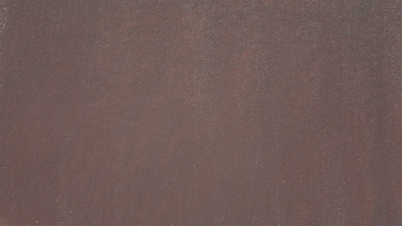 Stunning top down drone view of ocean waves crashing onto the sandy shore creating mesmerizing white foam patterns Perfect for relaxation meditation and beach lovers