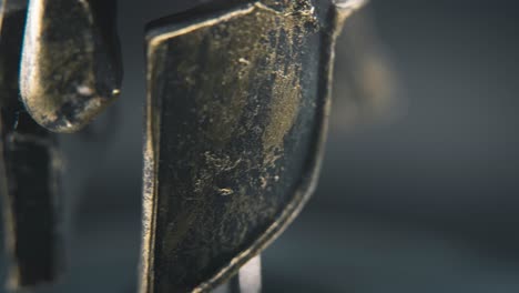 a close up macro detailed pan right shot of a spartan face design, warrior ancient greek bronze helmet, on a 360 rotating stand, studio lighting, 4k smooth movement