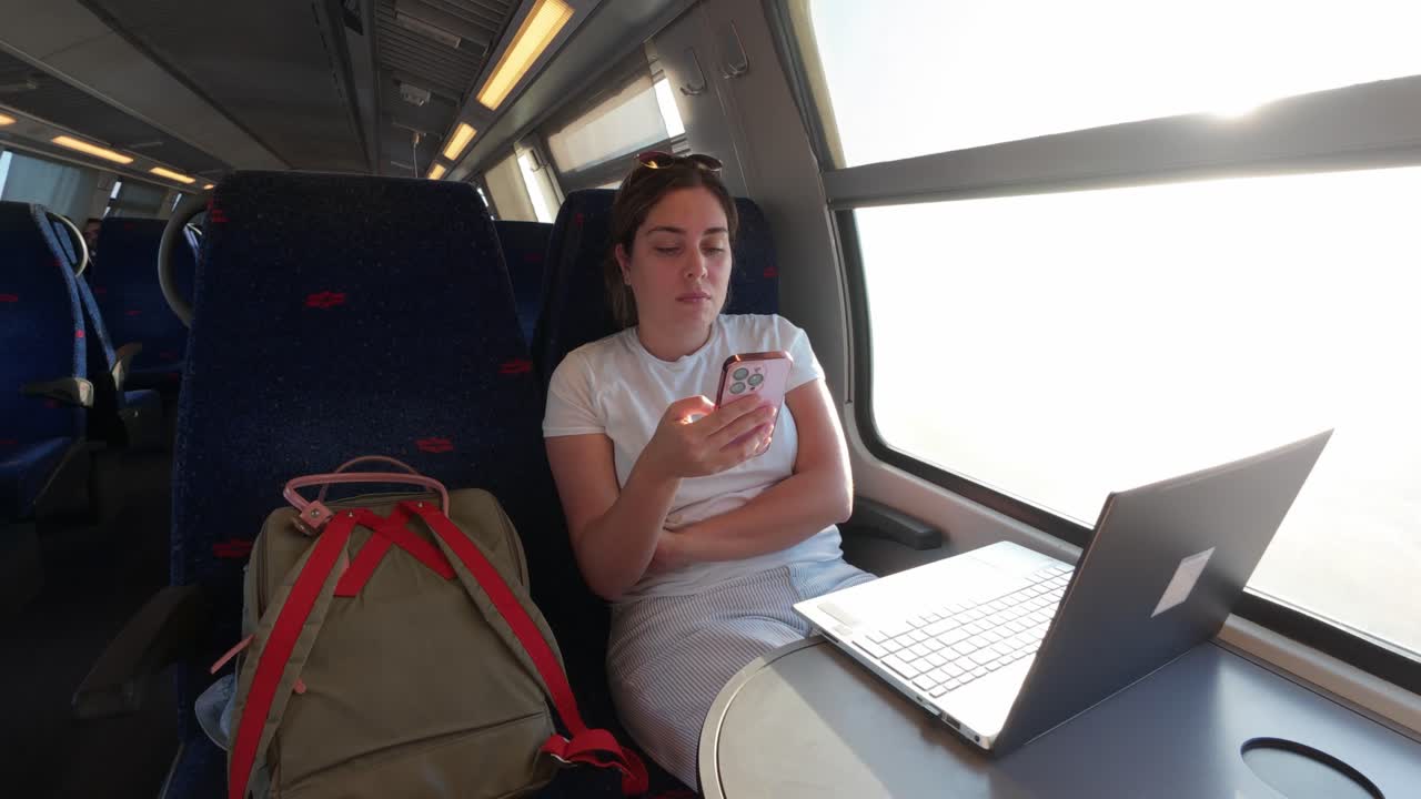 En kvinde med en digital livsstil på en pendlertur med toget om morgenen