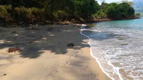 Walking-on-the-sand-of-the-beach-with-the-ocean-waves-hitting-the-sand-in-first-person-view