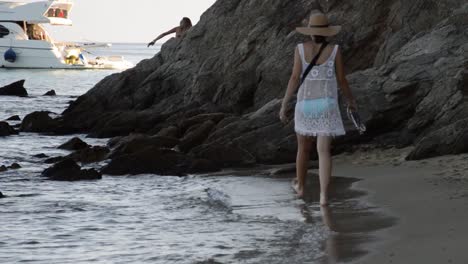 young woman walking around the beach thinking and playing with water