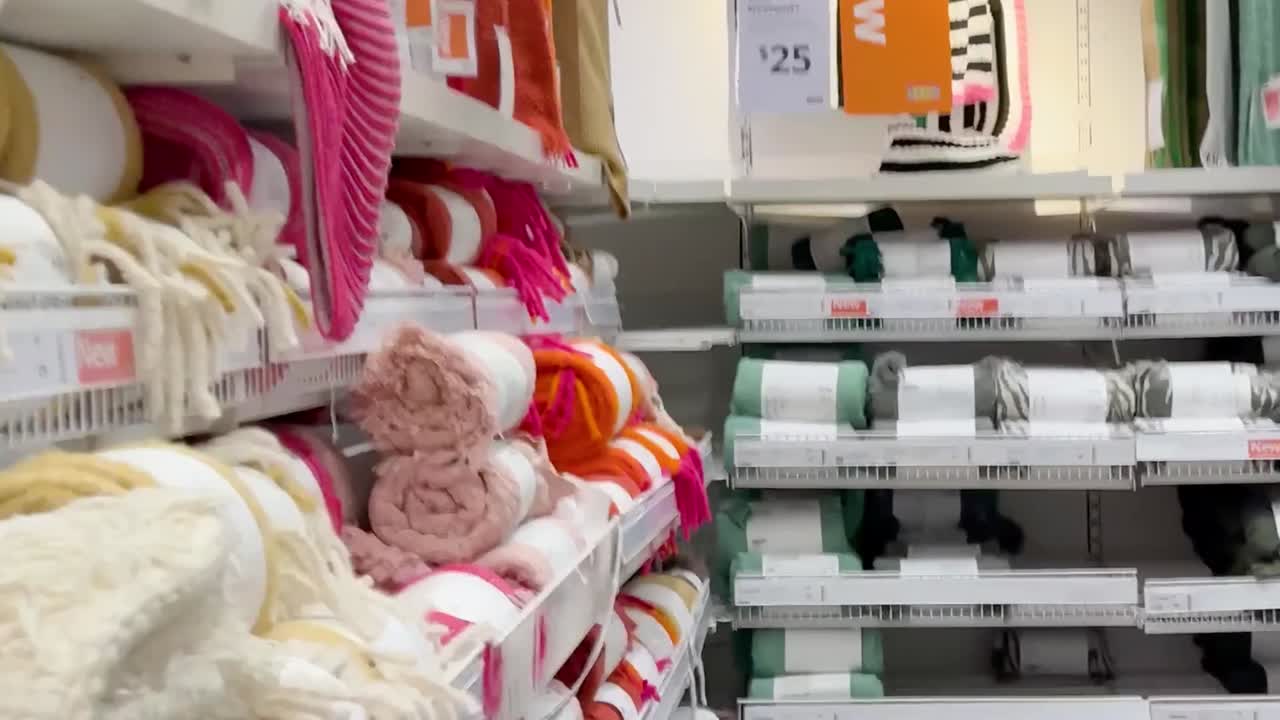 Utforsk levende tekstiler og organisert oppbevaring i et moderne butikkmiljø, med puter, håndklær og kurver