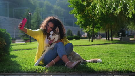 woman taking a selfie with her husky dog in a park