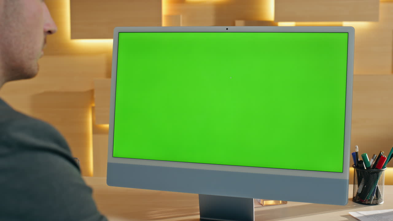 녹색 화면으로 컴퓨터에서 일하는 사업가