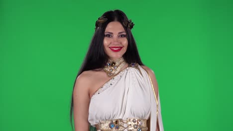 retrato de una mujer hermosa en grecia grecia vestido de oro y corona alta moda está mirando derecho y sonriendo. pantalla verde