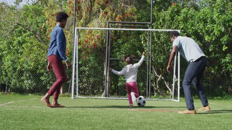 Happy-african-american-family-playing-football-in-park