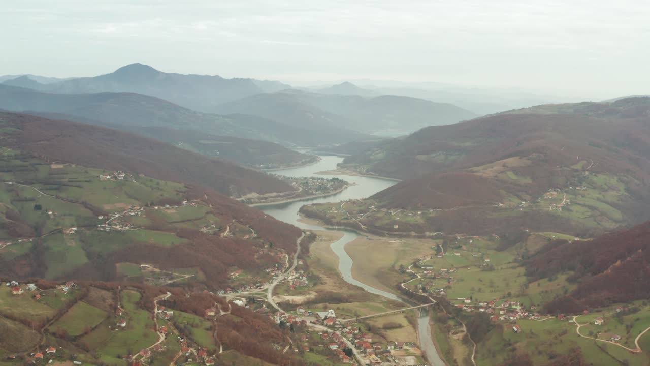 Paesaggio di catene montuose con vista cittadina durante una giornata nebbiosa a Tutin in Serbia.
