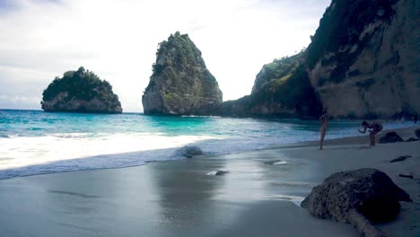 Landscape-shot-of-tourists-in-the-shade-of-a-white-sand-beach-with-clear-waters-during-a-beautiul-sunny-day-in-Bali