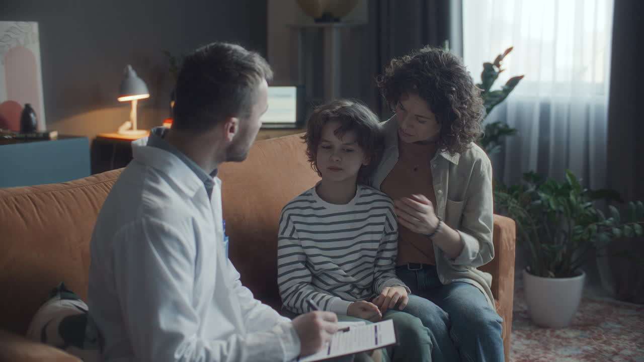 어머니 와 어린 아들 이 가정 의 의사 상담 중 의 의사 와 대화 하고 있다