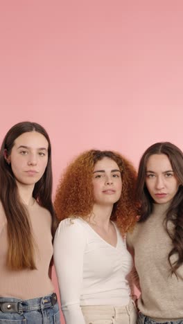 young women showing thumbs down on pink background