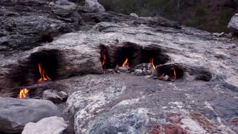 eternal flames: natural gas fireplace burning out of stone rocks at mount chimaera, turkey