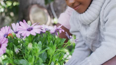 niña afroamericana trabajando en el jardín en un día soleado.