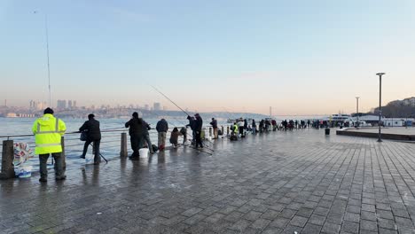 people fishing on a pier in istanbul at sunrise