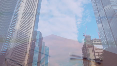 composite video of mid section of businessman and businesswoman shaking hands against tall buildings