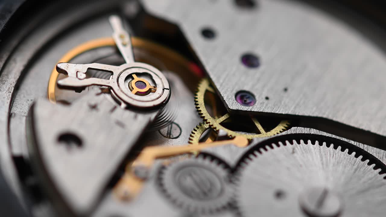 Internal working mechanism of the wristwatch with a rapidly rotating pendulum and gears. 4k clock close up with shallow depth of field