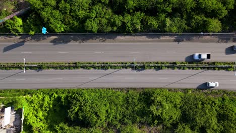 Drohne-Von-Oben-Nach-Unten,-Statische-Ansicht-Von-Kleinwagen,-Die-Auf-Einer-Mehrspurigen-Autobahn-Auf-Einer-Tropischen-Insel-Fahren