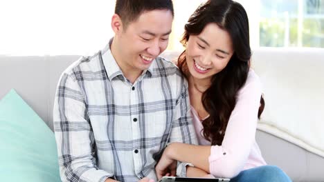 Happy-couple-using-tablet-together-