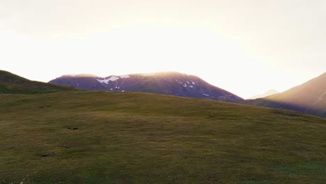 setting sun behind rocky ridgeline of colorado mountains spreads vibrant yellow rays across cool shaded blue guanella pass landscape