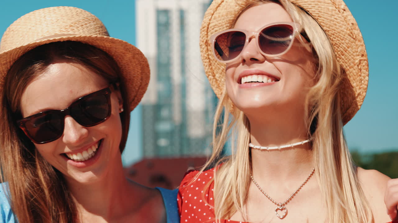 두 명의 행복한 여성들이 도시에서 여름날을 즐기고 있습니다.